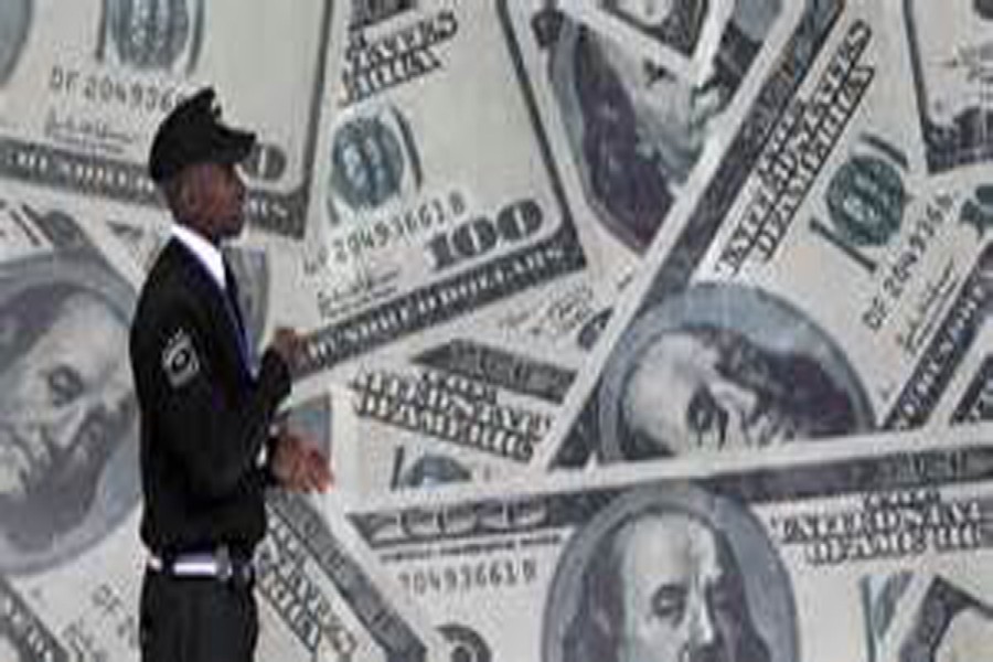 A security guard walks past a montage of US $100 bills outside a currency exchange bureau in Kenya's capital Nairobi. 	— Reuters