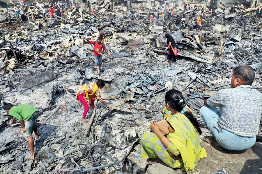 Residents of a slum at Mirpur-12 try to trace their belongings amid debris after a terrible fire burnt to ashes more than 4,000 shanties there on Monday. 	— FE Photo by Shafiqul Alam