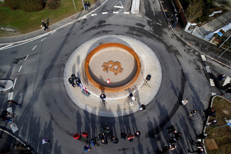 People attend the opening ceremony of world's first public Bitcoin monument, placed at a roundabout connecting two roads at the city centre in Kranj, Slovenia, March 13, 2018. Reuters