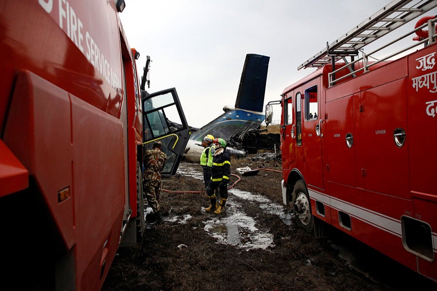 Rescue workers work at the wreckage of a U.S.-Bangla airplane after it crashed at the Tribhuvan International Airport in Kathmandu, Nepal on Monday. - Reuters photo