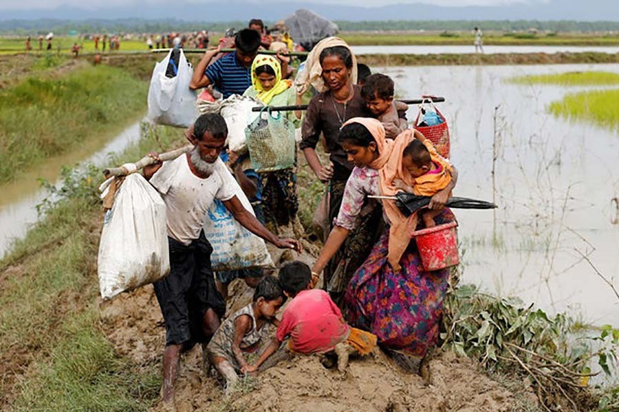 A group of Rohingya refugee people walk on the muddy path after crossing the Bangladesh-Myanmar border in Teknaf of Cox's Bazar last year. -Reuters Photo