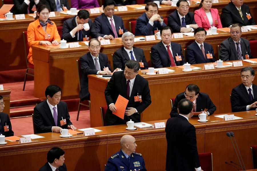 Chinese President Xi Jinping walks with his ballot before a vote at the fifth plenary session of the National People's Congress (NPC) at the Great Hall of the People in Beijing, China March 17, 2018. Reuters