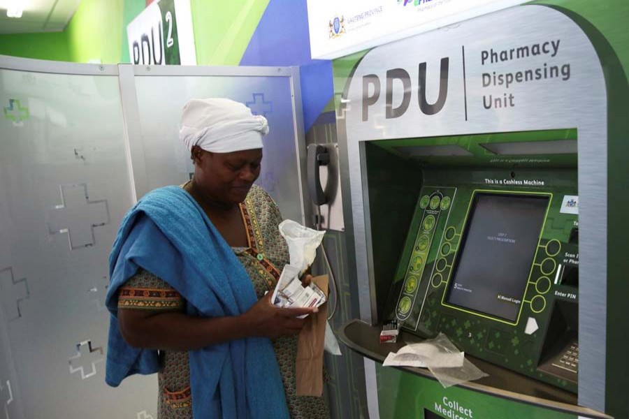 Rebecca Palai withdraws her medication at an ATM pharmacy which allows patients with chronic illnesses to receive repeat medication within three minutes, in Alexander township, South Africa, March 15. Reuters/File photo