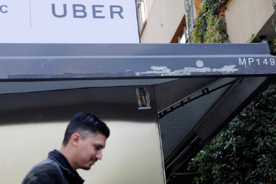 A man walks by under an Uber logo in Mexico City, Mexico February 6, 2018. Reuters