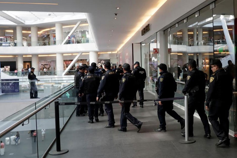 Police work outside a footwear shop after a man shot a woman in the abdomen there, before shooting himself in the head according to the police statement in Mexico City, Mexico March 19, 2018. Reuters.