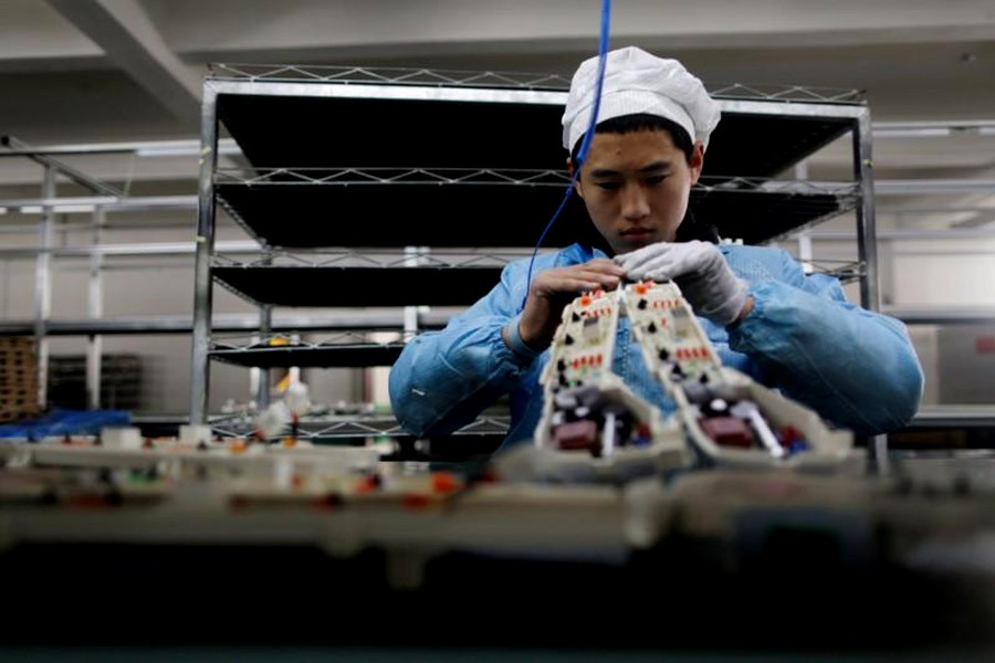 A labourer is working inside an electronics factory in Qingdao of Shandong province in China. - Reuters file photo