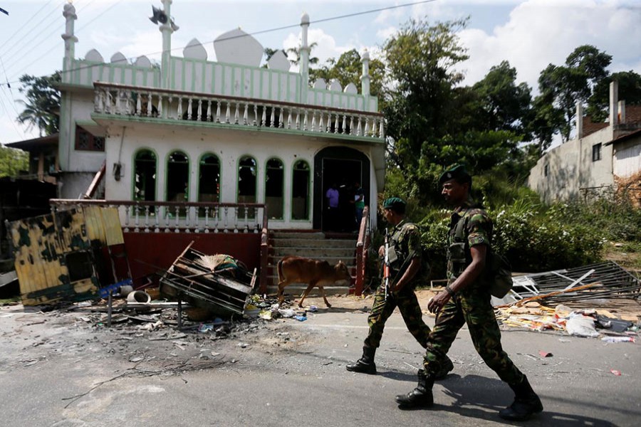 Sri Lanka's Special Task Force soldiers walk past a damaged mosque after a clash between two communities in Digana, central district of Kandy, Sri Lanka on March 8 last - Reuters photo