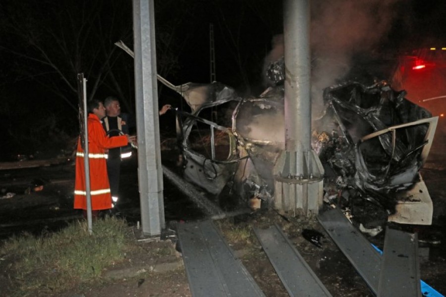 Firefighters try to extinguish fire of a wreckage of a minibus, carrying migrants, after it crashed into a light pole and caught fire in Igdir, Turkey on Friday - Anadolu Agency photo