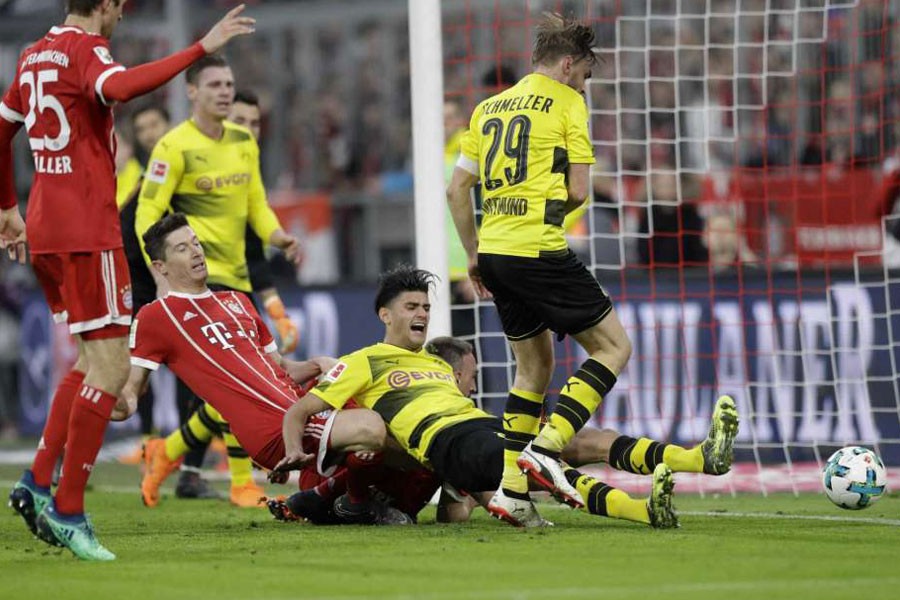 Bayern's Robert Lewandowski, left, scores his side's fourth goal during the German Bundesliga soccer match between FC Bayern Munich and Borussia Dortmund in Munich, Germany, Saturday, March 31, 2018. AP.