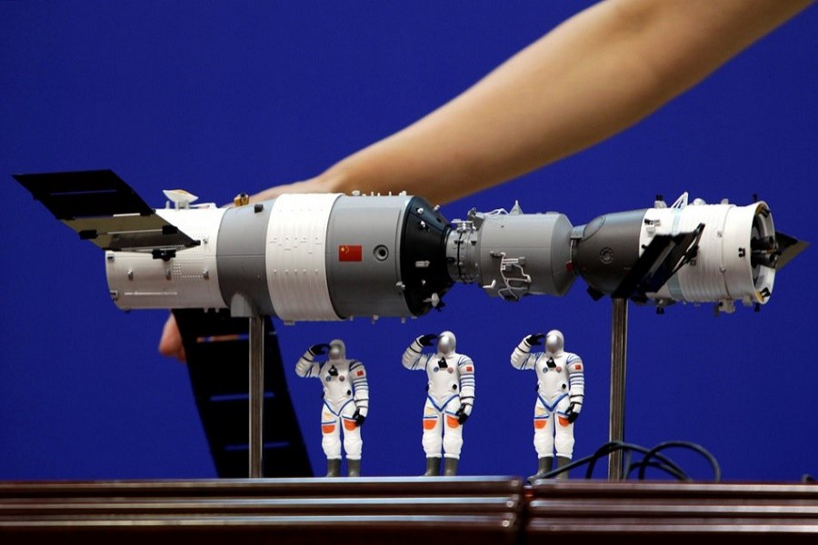 A model of the Tiangong-1 space lab module (L), the Shenzhou-9 manned spacecraft (R) and three Chinese astronauts is displayed during a news conference at Jiuquan Satellite Launch Center, in Gansu province, China June 15, 2012. Reuters/File Photo