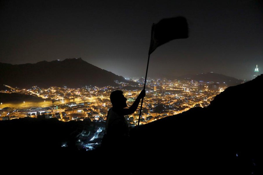 A muslim pilgrim waves a flag for his team at Mount Al-Noor, in the holy city of Mecca of Saudi Arabia last year. -Reuters Photo