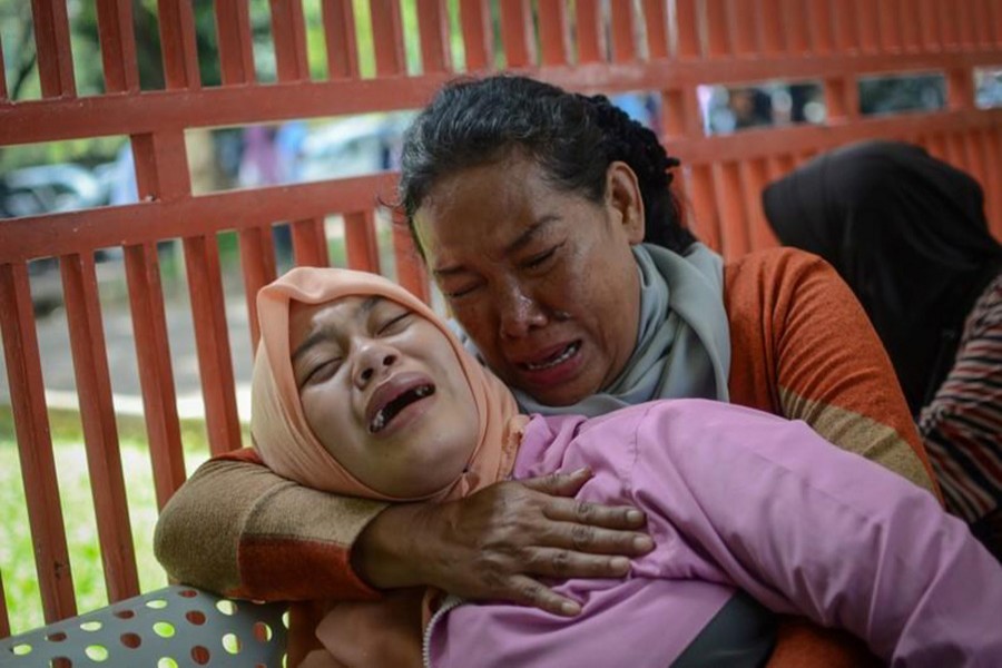 Relatives of a man, who died after consuming tainted homemade alcohol, cry outside of a hospital in Cicalengka, Bandung Regency, West Java, Indonesia on Monday - Reuters photo