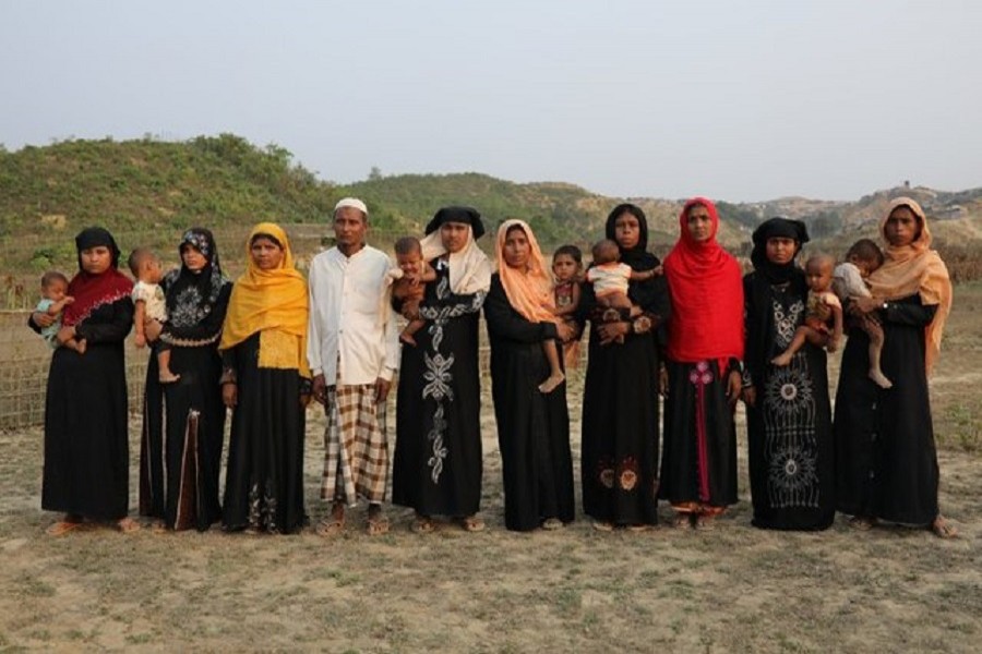 From left: Hasina Khatun, Marjan, Nurjan, Abdu Shakur, Shuna Khatu, Nurjan, Rahama Khatun, Amina Khatun, Settara, Hasina Khatun; relatives of ten Rohingya men killed by Myanmar security forces and Buddhist villagers on September 2, 2017, pose for a group photo in Cox's Bazar, Bangladesh, March 23, 2018. Reuters/Files