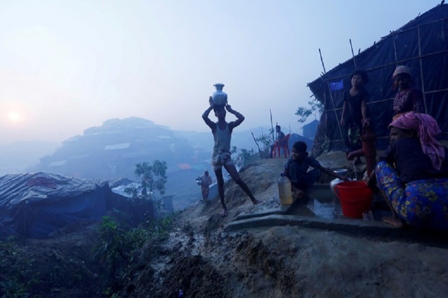 Rohingya refugees fill their containers with drinking water from a hand-pump at Balu Khali refugee camp near Cox's Bazar, October 26, 2017. Reuters/Files