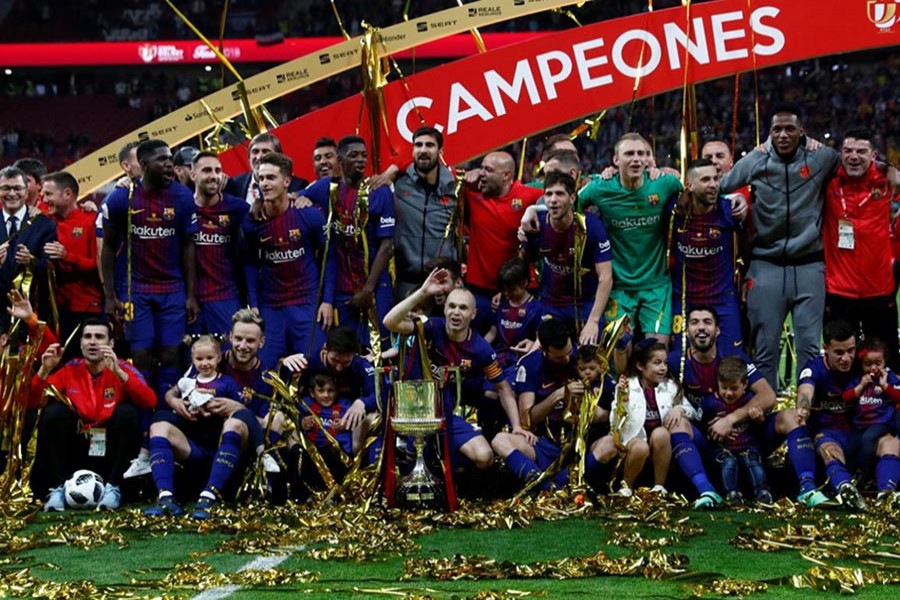 Barcelona's Andres celebrates with the trophy and teammates after the match on Saturday - Reuters photo