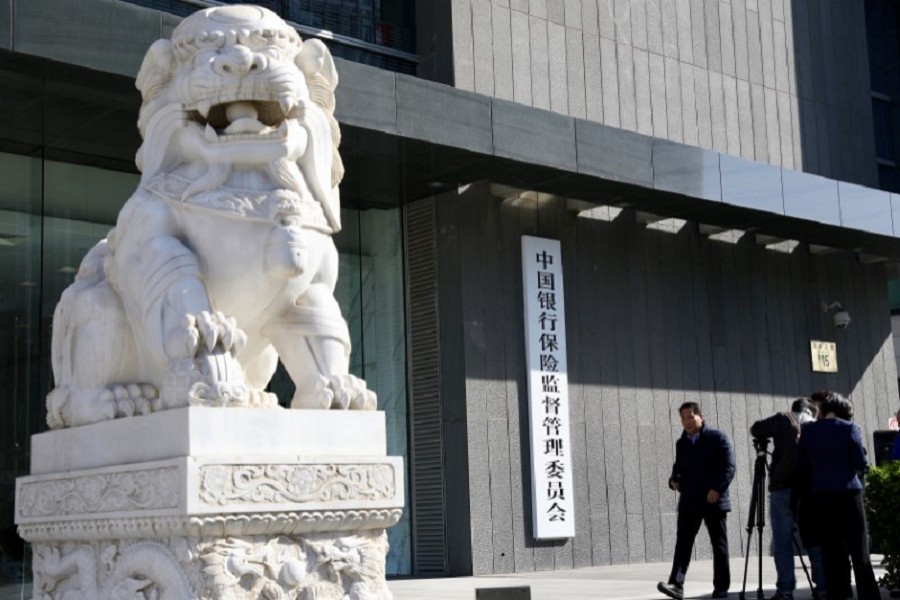 People film the new sign of China Banking and Insurance Regulatory Commission (CBIRC), the newly merged regulatory body, at its office in Beijing, China April 8, 2018. Reuters/Files