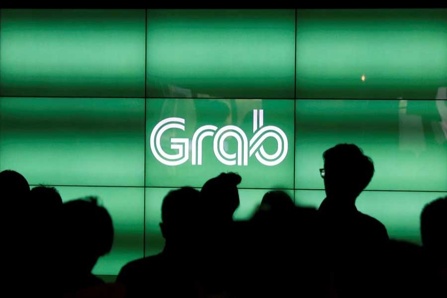 People wait for the start of Grab's fifth anniversary news conference in Singapore on June 6, 2017. Reuters/Files