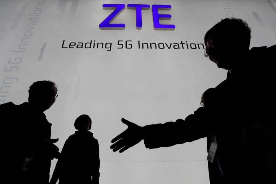 Visitors pass in front of the Chinese telecoms equipment group ZTE Corp booth at the Mobile World Congress in Barcelona, Spain, February 26, 2018. Reuters/File Picture