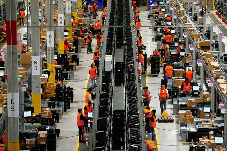 Employees handle packages in the new Amazon logistic centre in Dortmund, Germany on November 14 last - Reuters/File