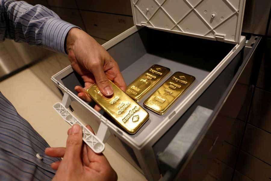 An employee puts gold bullion into a safe deposit box at Degussa shop in Singapore, June 16, 2017. Reuters/Files