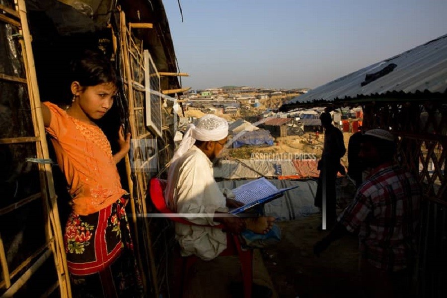 A Rohingya refugee religious cleric reads a holy book outside his makeshift shelter in Kutupalong refugee camp near Cox's Bazar on January 19 this year. AP/File Photo