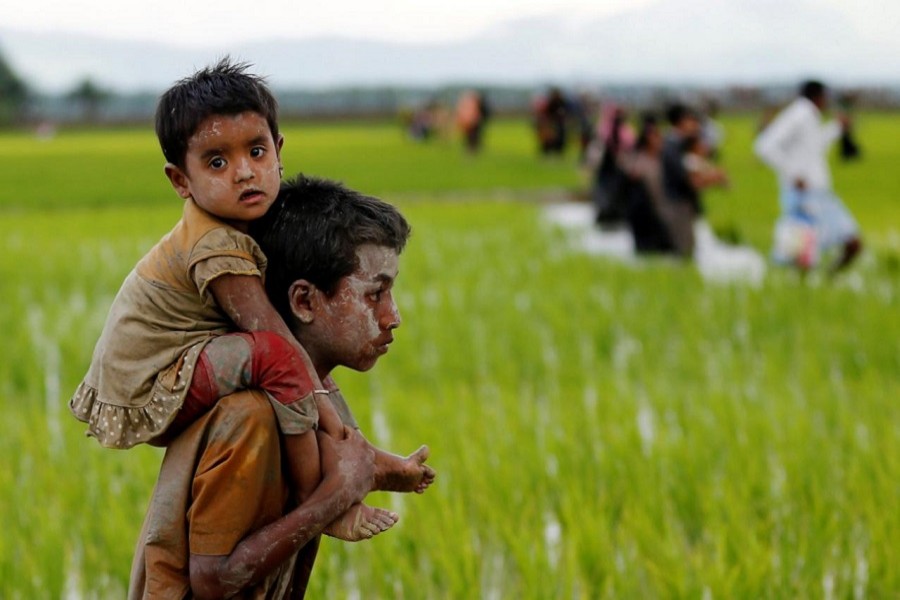 A Rohingya boy carries a child after after crossing the Bangladesh-Myanmar border in Teknaf, Bangladesh, September 1, 2017. Reuters/Files