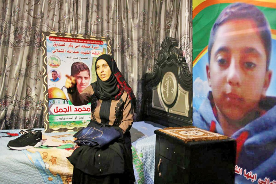 Mother of Palestinian Hiatham Al-Jamal (15), who was killed during a protest on the Israel-Gaza border, gesturing as she shows clothes he bought to wear during Eid ul-Fitr holiday, in Gaza Strip on Thursday 	— Reuters