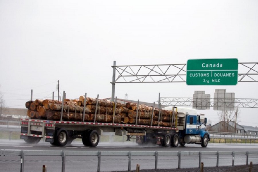 A truck carrying logs heads toward the Canada border in Champlain, New York, April 25, 2017. Reuters/File Photo