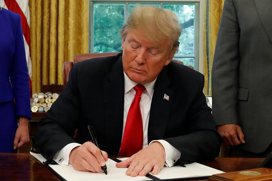 US President Donald Trump signs an executive order on immigration policy in the Oval Office of the White House in Washington, US on Wednesday - Reuters photo