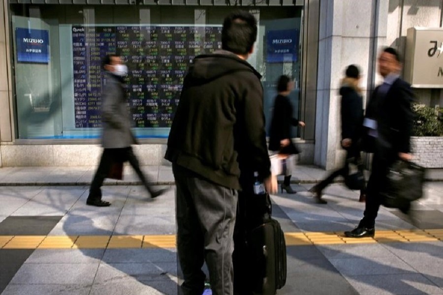 A man looks at an electronic stock quotation board outside a brokerage in Tokyo, Japan, February 9, 2018. Reuters/Files