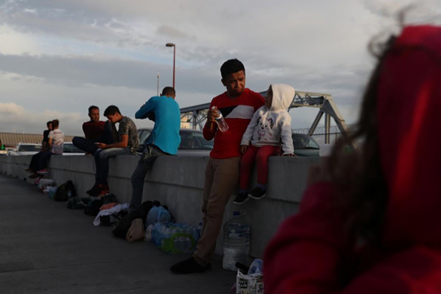 Asylum seekers wait on the Mexican side of the Brownsville & Matamoros International Bridge after being denied entry by US Customs and Border Protection officers near Brownsville, Texas, US on. Sunday - Reuters photo