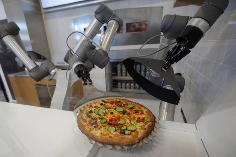 A pizzaiolo robot prepares a pizza before the customer’s eyes at the showroom of French food startup EKIM in Montevrain near Paris, France on June 26. Reuters photo