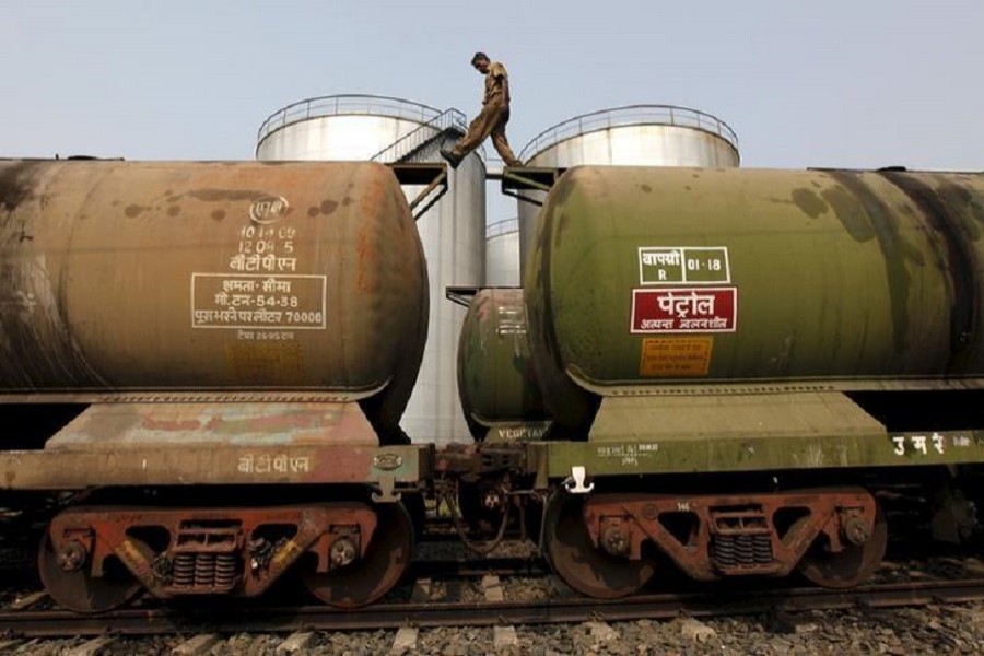 A worker walks atop a tanker wagon to check the freight level at an oil terminal on the outskirts of Kolkata, India, November 27, 2013. Reuters/File Photo