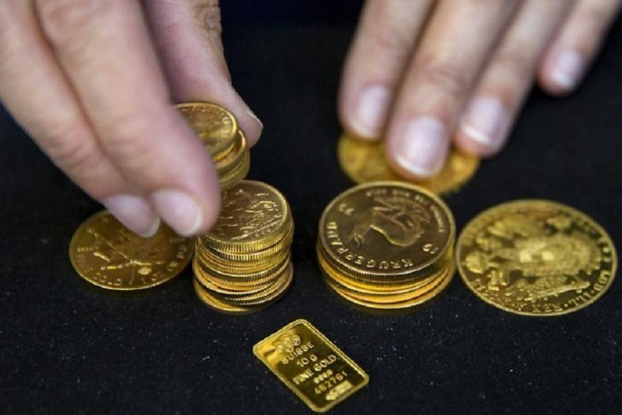 A worker places gold coins on display at Hatton Garden Metals precious metal dealers in London, Britain, July 21, 2015. Reuters/File Photo