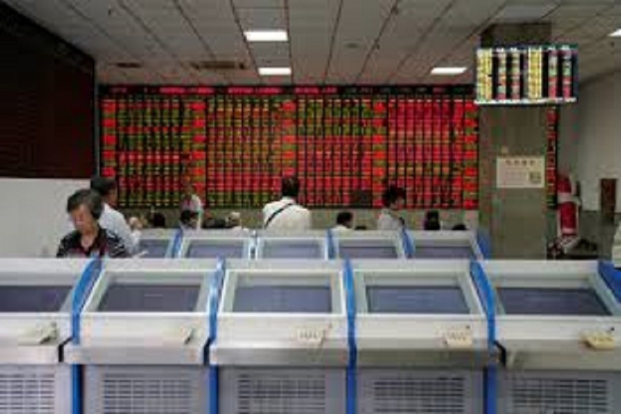 People look at an electronic board showing stock information at a brokerage house in Shanghai, China, July 6, 2018. Reuters