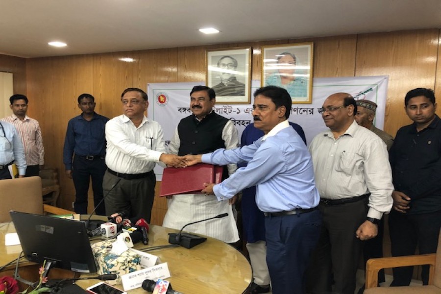 Secretary of the Ministry of Shipping Md Abdus Samad and Managing Director of BCSCL Md Saiful Islam exchanging documents after signing an agreement in the capital on Sunday.