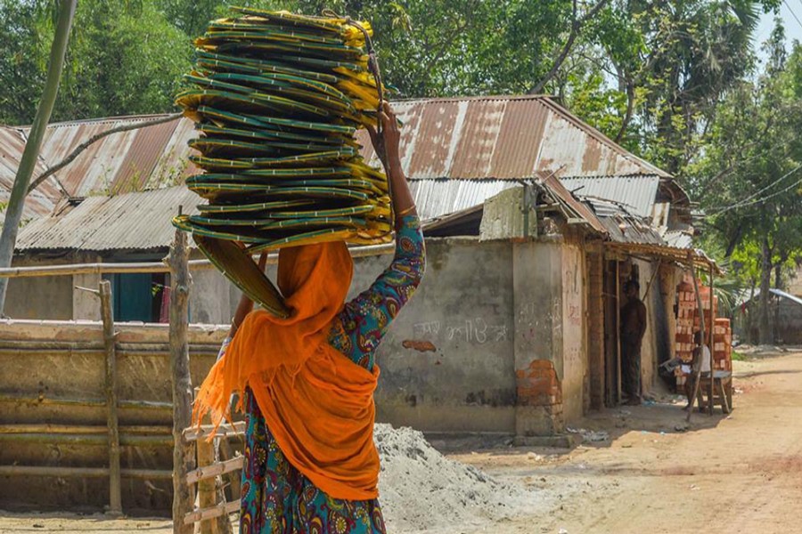 JOYPURHAT: A female vendor selling handfans moving from door to door under Akkelpur upazila of Joypurhat district. 	— FE Photo