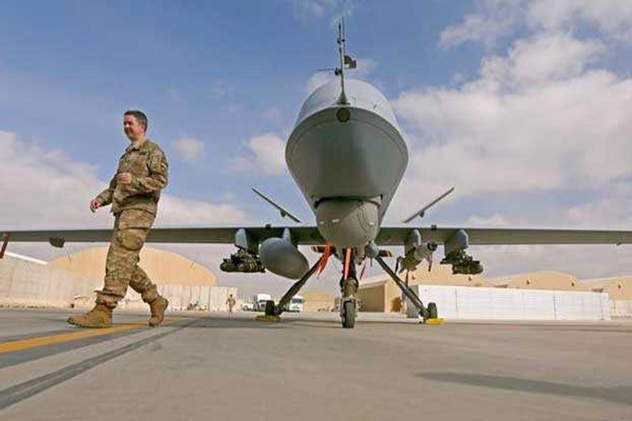 US service member passing in front of an MQ-9 Reaper drone	— Reuters