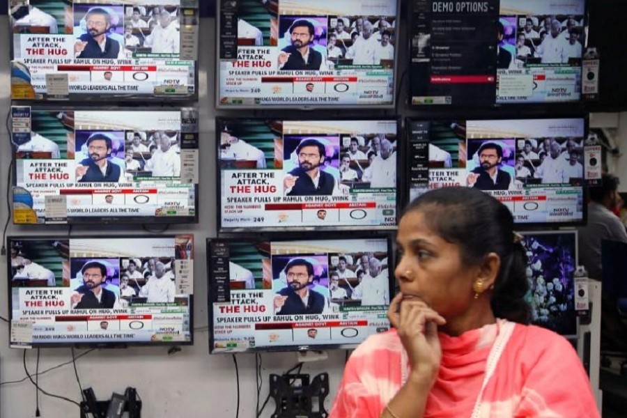 A woman watches a news television debate about opposition leader Rahul Gandhi's hug to Prime Minister Narendra Modi during a no-confidence motion in parliament, at an electronics store in Kolkata, India, July 20, 2018. Reuters