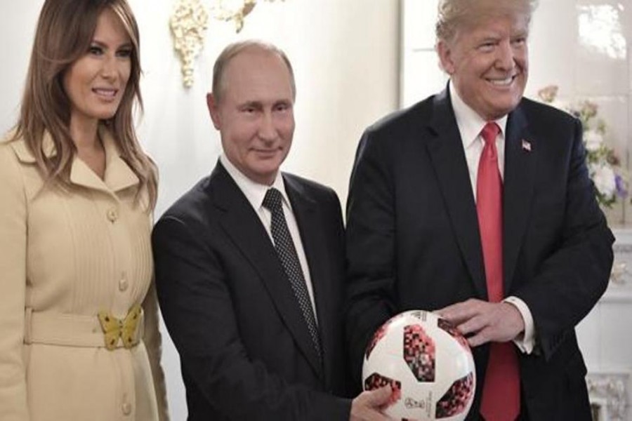 US First Lady Melania Trump, left, Russian President Vladimir Putin, center, and US President Donald Trump, pose with a soccer ball after a press conference following their meeting at the Presidential Palace in Helsinki, Finland, Monday, July 16, 2018. - AP