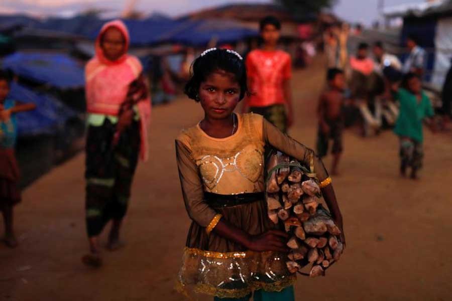 Yasmin, a 10-year-old Rohingya refugee girl, poses while carrying firewood at Kutupalong refugee camp near Cox's Bazar, Bangladesh, October 13, 2017. Reuters/File PhotoYasmin, a 10-year-old Rohingya refugee girl, poses while carrying firewood at Kutupalong refugee camp near Cox's Bazar, Bangladesh, October 13, 2017. Reuters/File Photo