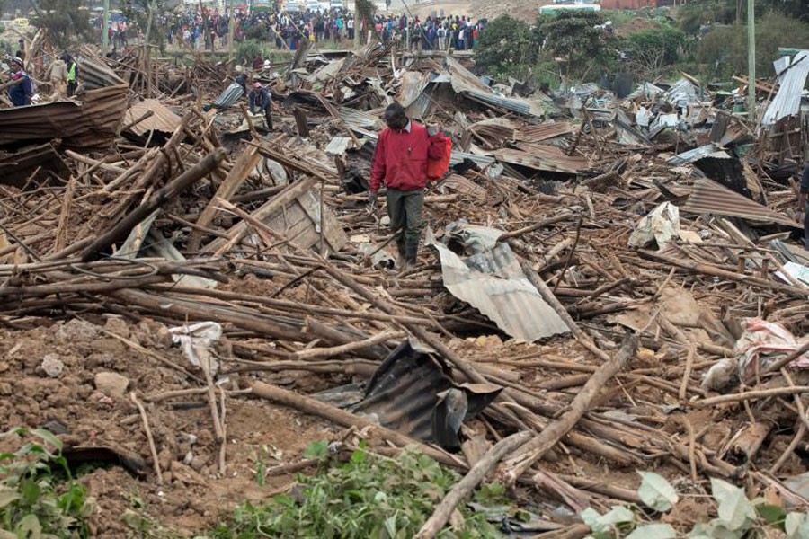 A man looks through the rubble of houses demolished to make way for a new road in the Kibera slum in Nairobi – Reuters