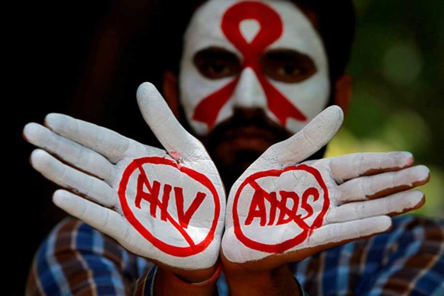 A student displays his hands painted with messages as he poses during an HIV/AIDS awareness campaign to mark the International AIDS Candlelight Memorial, in Chandigarh, India. - Reuters