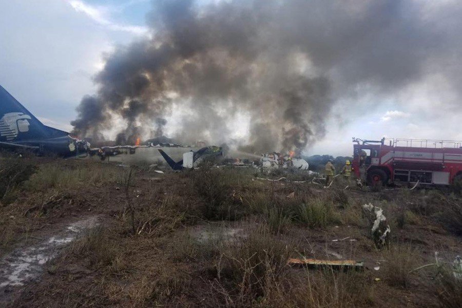 Firefighters douse a fire as smoke billows above the site where an Aeromexico-operated Embraer passenger jet crashed in Mexico's northern state of Durango, July 31, 2018, in this picture obtained from social media - Proteccion Civil Durango/via Reuters