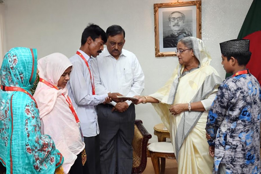 PM Hasina handing over a saving certificate to the father of Diya Khanam Mim — one of the victims who died in the city road crash on July 29 — BSS photo