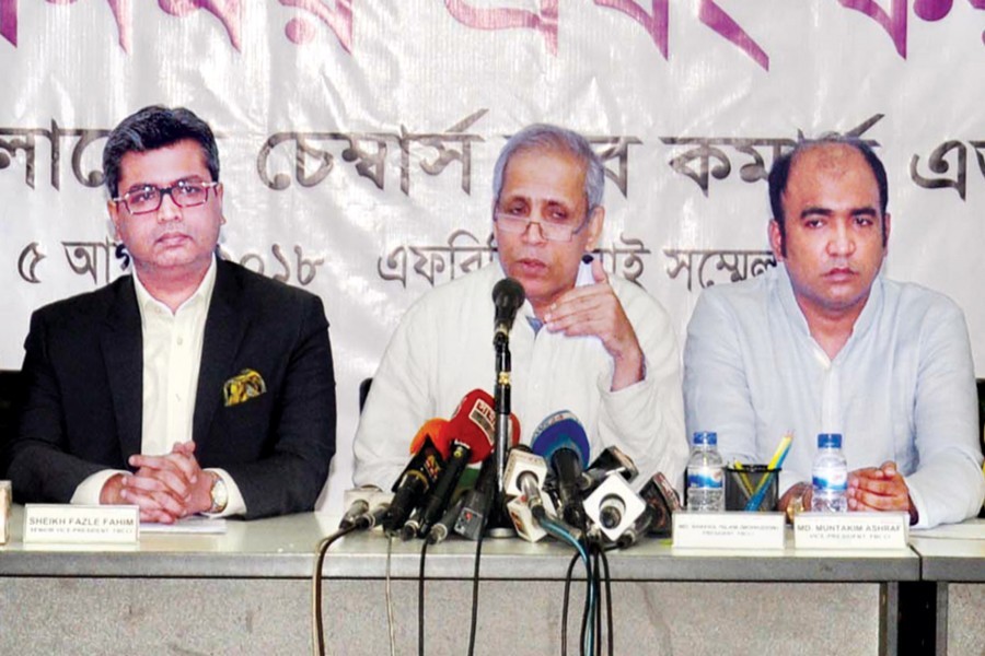 FBCCI president, flanked by two vice-presidents, speaking at a press conference