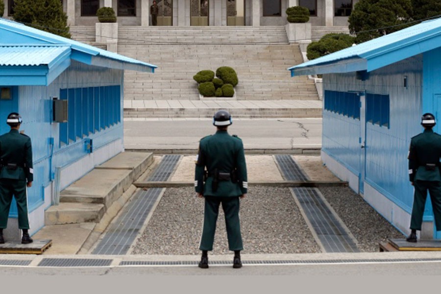 A North Korean soldier, centre top, looks at the southern side as South Korean soldiers stand guard at the border village of Panmunjom, which has separated the two Koreas since the Korean War, in Paju, north of Seoul, South Korea, Wednesday, April 10, 2013 – AP photo