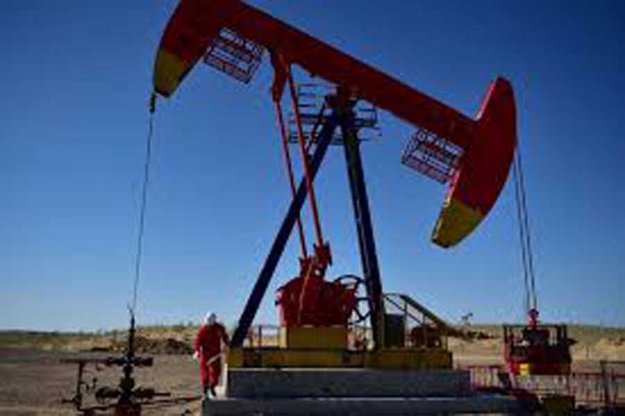 A worker inspects a pump jack at an oil field in Tacheng, Xinjiang Uighur Autonomous Region, China June 27, 2018. Reuters/File Photo