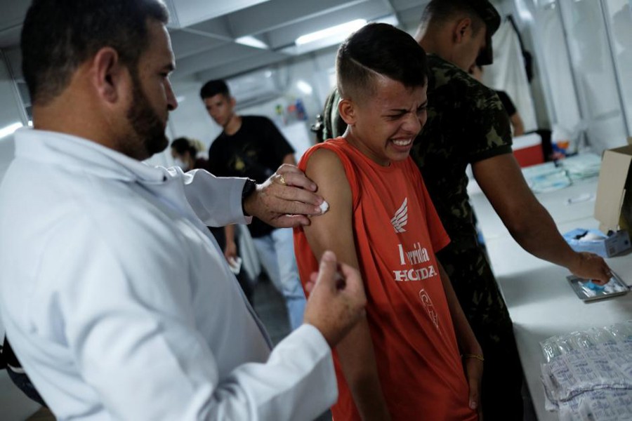 A Venezuelan boy receives a free vaccination given by a volunteer after showing his passport at the Pacaraima border control, Roraima state, Brazil August 9, 2018. Reuters photo