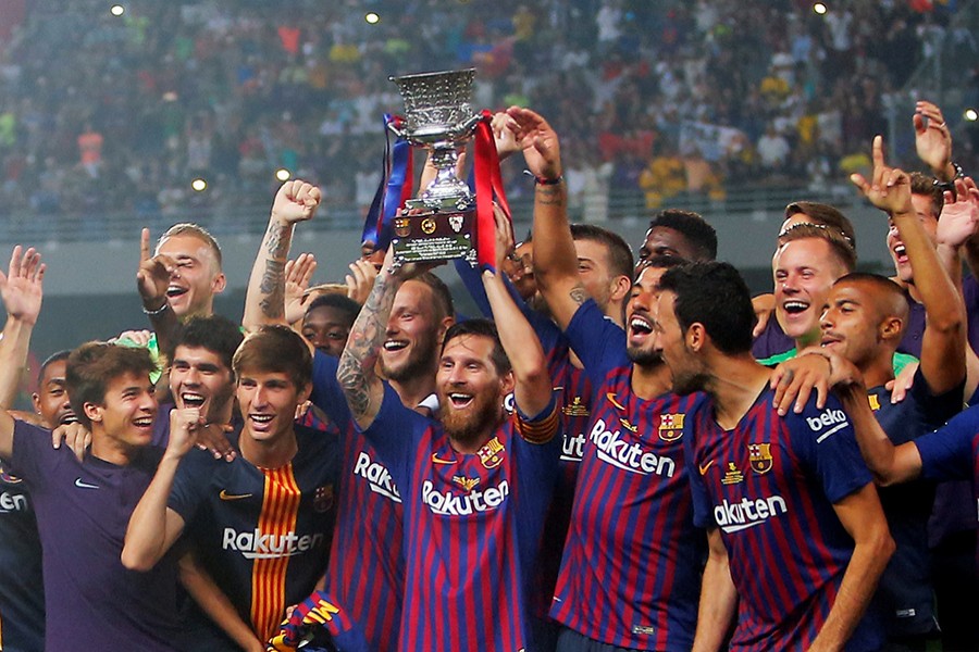 Barcelona's Lionel Messi lifts the trophy as he celebrates winning the Spanish Super Cup with teammates — Reuters